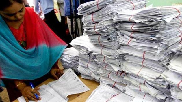 Tax officials scrutinising a tax return form in New Delhi.(AFP File Photo)