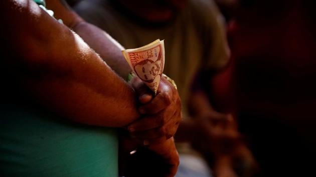 A cockfighting enthusiast holds money during a fight at the arena. (Alexandre Meneghini / Reuters)