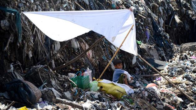 A boy rests in the shade while waiting for his father to salvage items from a garbage dump in Denpasar. (Sonny Tumbelaka/AFP) A boy rests in the shade while waiting for his father to salvage items from a garbage dump in Denpasar. (Sonny Tumbelaka/AFP)
