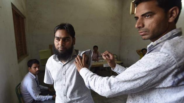 28-year-old Aas Mohammed gets his arm inked after casting his vote in MCD elections at Jamia Nagar. First three hours of voting for Delhi municipal polls saw thin turnout with election officers in Delhi village areas waited for voters. (Raj K Raj/HT Photo)