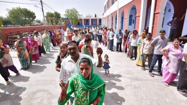 People wait in a queue to cast their vote at Burari polling station. Over 1.32 crore Delhi voters likely to cast their votes to choose councillors in 272 wards for three corporations — North, East, South. While the North and South corporations have 104 wards each, the East ward has 64 wards. (Arun Sharma/HT Photo)