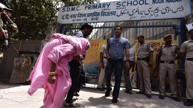 An elderly woman enters a polling booth to cast her vote at Noor Nagar. Meanwhile, Delhi Police said that it has already received at least 300 calls related to municipal elections till 11 am. (Burhaan Kinu/HT Photo)