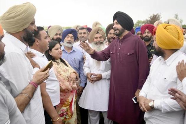 Punjab local bodies minister Navjot Singh Sidhu meeting farmers of village Othianto whose wheat crop was destroyed in fire, on Saturday.(Sameer Sehgal /HT)