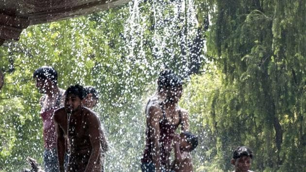 Youngsters beat the heat at a fountain near India Gate as temperature rises in New Delhi.(PTI Photo)