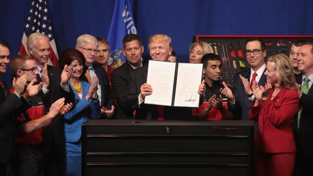 President Donald Trump signs an executive order to try to bring jobs back to American workers and revamp the H-1B visa guest worker programme during a visit to the headquarters of tool manufacturer Snap-On on April 18, 2017 in Kenosha, Wisconsin.(AFP)