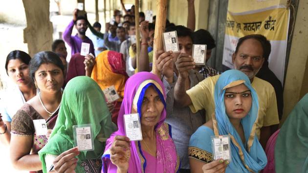 Voters stand in a queue at a polling station at Madanpur Khadar in New Delhi on Sunday.(Raj K Raj/Hindustan Times)