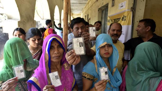 Voters stand in a queue at a polling station at the cast their votes at Madanpur khadar in New Delhi on Sunday.(Raj K Raj/HT PHOTO)