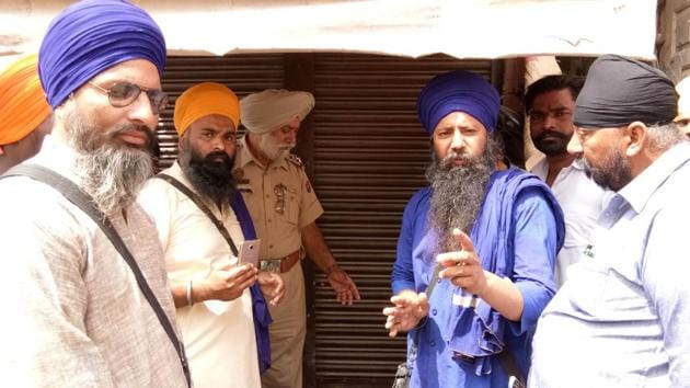 Members of Guru Granth Sahib Satkar Committee along with policemen raiding a shop near the Golden Temple in Amritsar on Saturday.(HT Photo)
