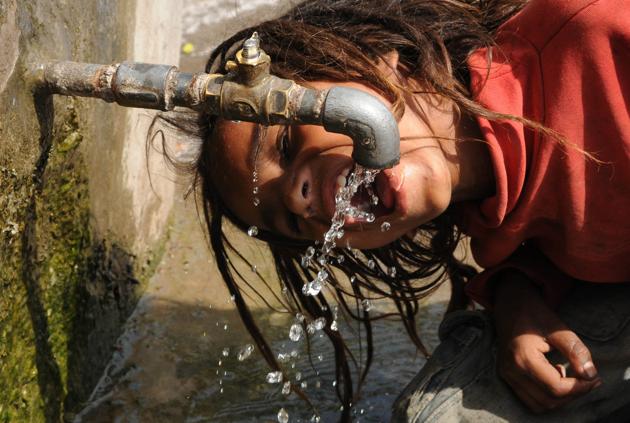 Patiala, India-23 April 2017::::A boy drinks dripping water from a public tap in tractor market in Patiala on Sunday, April 23, 2017.Photo by Bharat Bhushan Hindustan Times. Patiala, India-23 April 2017::::A boy drinks dripping water from a public tap in tractor market in Patiala on Sunday, April 23, 2017.Photo by Bharat Bhushan Hindustan Times.