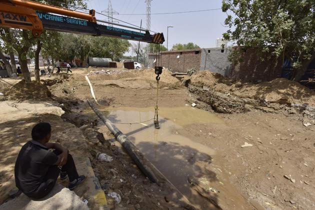 The leak in Huda water pipeline near Rajiv Chowk being repaired on Monday.(Sanjeev Verma/HT PHOTO)