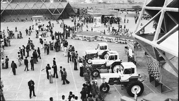 Visitors at Pragati Maidan exhibition ground looking at the range of tractors displayed at a pavilion in New Delhi. (SN Sinha / HT Photo)