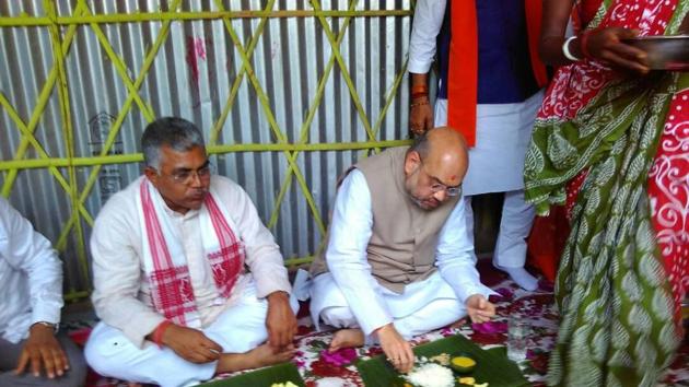 BJP president Amit Shah and the party’s Bengal unit chief Dilip Ghosh during lunch at a scheduled tribe couple’s hut in Naxalbari in north Bengal on Tuesday.(HT PHOTO)