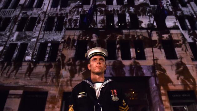 A serviceman stands in front of a building projecting world war pictures near the Cenotaph during the Anzac Day Dawn Service in Sydney. Dawn services were held across the two countries on the anniversary of the ill-fated 1915 campaign of the Australian and New Zealand Army Corps that left 11,500 of them dead in what is now Turkey during World War I. (Saeed Khan/AFP)