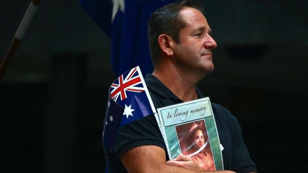 A relative of a veteran carries an Australian national flag and photograph as a tribute. Forty-two Australians have died while on military service in Afghanistan and two in Iraq since 2002. (David Gray/REUTERS)