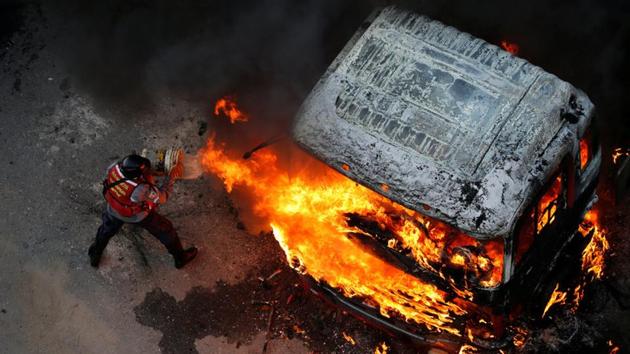A fireman tries to extinguish a fire. (Carlos Garcia Rawlins/REUTERS) A fireman tries to extinguish a fire. (Carlos Garcia Rawlins/REUTERS)