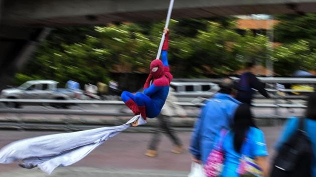 Duque hangs a white cloth of about 26 meters-his ‘cobweb- in the bridge of the 100th street with fifteen career, a busy vehicular bridge near the international center of Bogota. (Raul Arboleda / AFP)