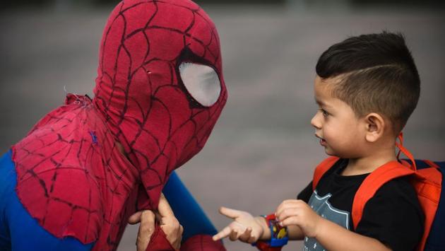 Colombian Jahn Fredy Duque, dressed as superhero ‘ Spiderman’ , talks to a little boy while performing on the streets in Bogota. (Raul Arboleda / AFP)