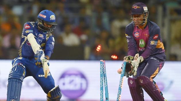 Mumbai Indians cricketer Parthiv Patel is bowled out as Rising Pune Supergiants cricketer Mahendra Singh Dhoni looks on. (AFP)