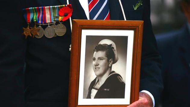 A relative of a veteran carries a photograph as a tribute during the annual ANZAC (Australian and New Zealand Army Corps) Day march through central Sydney, Australia. The day marks the landing of thousands of troops from the Australian and New Zealand Army Corps (ANZAC) on the Gallipoli peninsula in Turkey on April 25, 1915. (David Gray/REUTERS)