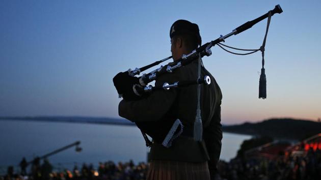 A bagpiper performs during the Dawn Service ceremony at the Anzac Cove beach in Gallipoli peninsula, in Turkey. Television footage showed veterans and their families marching by flag-waving crowds and laying wreaths at war memorials in Sydney and other Australian cities. (Emrah Gurel/AP)