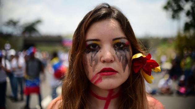 A Venezuelan opposition activist participates in a sit-in to block the Francisco Fajardo motorway in Caracas. On Monday, protesters blocked Venezuela's main roads including the capital's biggest motorway, triggering fears of further violence after three weeks of unrest. (Ronaldo Schemidt/AFP) A Venezuelan opposition activist participates in a sit-in to block the Francisco Fajardo motorway in Caracas. On Monday, protesters blocked Venezuela's main roads including the capital's biggest motorway, triggering fears of further violence after three weeks of unrest. (Ronaldo Schemidt/AFP)