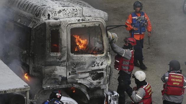 Fire-fighters put out a truck set on fire during anti-government protests in Caracas. The latest casualties come on a day anti-Maduro demonstrators blocked major roads in the South American nation. (Fernando Llano/AP) Fire-fighters put out a truck set on fire during anti-government protests in Caracas. The latest casualties come on a day anti-Maduro demonstrators blocked major roads in the South American nation. (Fernando Llano/AP)