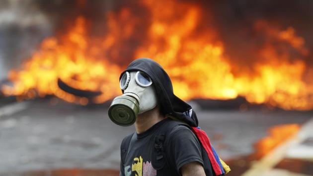 An anti-government protester stands in front of burning barricade on a highway in Caracas. A recent survey by pollster Venebarometro indicated that seven out of 10 Venezuelans disapprove of Maduro. (Ariana Cubillos/AP) An anti-government protester stands in front of burning barricade on a highway in Caracas. A recent survey by pollster Venebarometro indicated that seven out of 10 Venezuelans disapprove of Maduro. (Ariana Cubillos/AP)