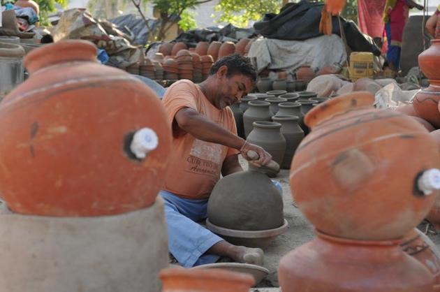 A potter working on earthen water coolers in Mansoorwal village on the outskirts of Kapurthala on Wednesday, April 26. (Pardeep Pandit/HT) 