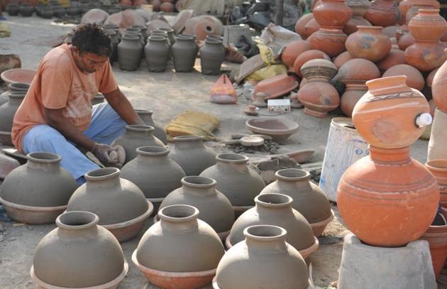 A potter working on earthen water coolers in Mansoorwal village on the outskirts of Kapurthala on Wednesday, April 26. (Pardeep Pandit/HT) 