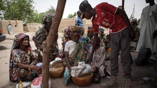 A member of Civilian Joint Task Force (CJTF) screens women at the entrance of the town of Damasak in North East Nigeria on April, 25 2017 as thousands of Nigerians, who were freed in 2016 by the Nigerian army from Boko Haram insurgents, are returning to their homes . (Florian Plaucheur / AFP)