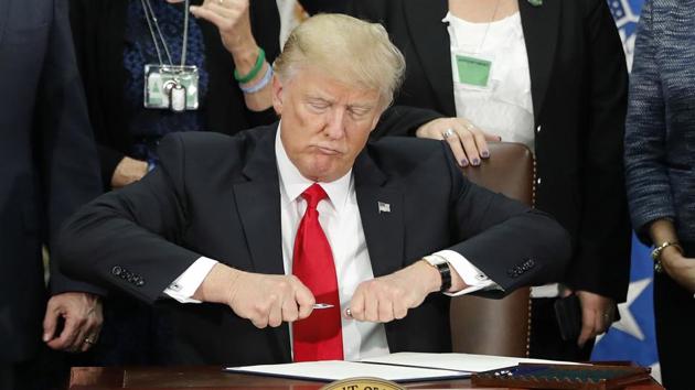 US President Donald Trump on Day 6, signing an executive order for immigration actions to build his border wall.(AP)