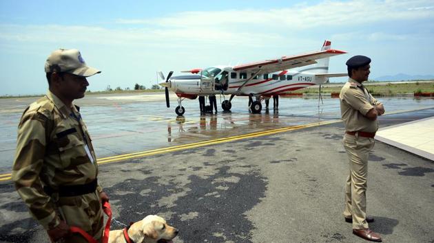 Security personnel wait for passengers to board an aircraft on the runway of the Shimla Airport. (Deepak Sansta / HT Photo)