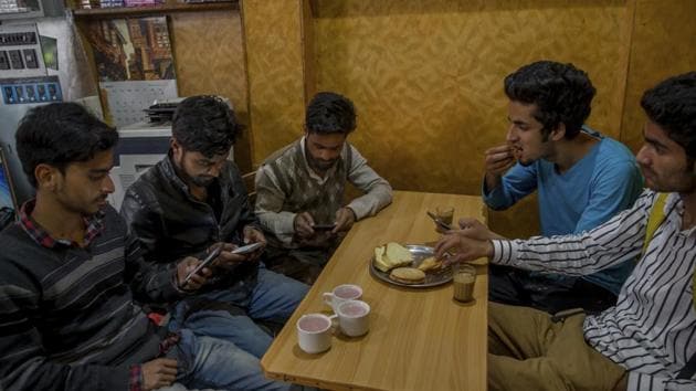 Kashmiri students browse internet on their mobile phones in Srinagar. By banning social media websites such as WhatsApp, Facebook, and Twitter, the government is encouraging people to find alternative ways of resistance, while inconveniencing millions of people who aren’t trying to brew discontent.(AP)