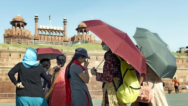 Visitors to the Red Fort cover themselves to protect from the heat. (Sonu Mehta/HT PHOTO)