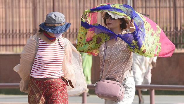 Japanese tourists on a hot and windy day at a monument in Delhi. (Sonu Mehta/HT PHOTO)