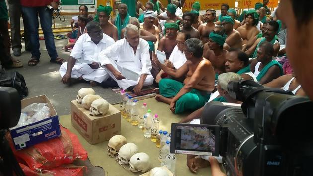 Farmers sit with urine collected in plastic bottles at Jantar Mantar during a protest.(HT Photo)