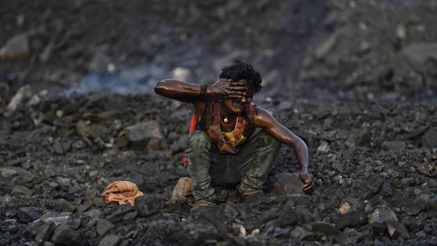 A man washes away dust from his face in a stagnant pool of water near the entrance of a mine. (Ravi Choudhary/HT PHOTO)