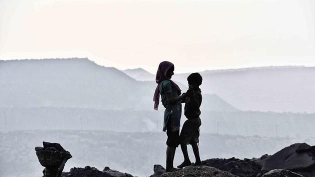 Children play at dusk in the backdrop of a sprawling open cast mine owned by BCCL, a public sector company that is part of Coal India. (Ravi Choudhary/HT PHOTO)