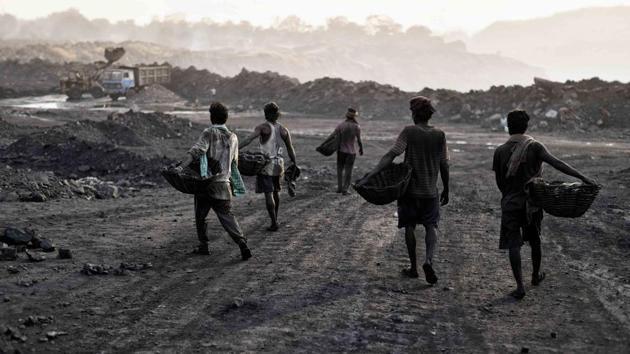 Daily wage workers return to a loading point later afternoon after filling up a truck laden with coal. (Ravi Choudhary/HT PHOTO)