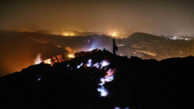 A man accompanying the photographer looks over the vast expanse of coal rock strata that has been burning for several decades. (Ravi Choudhary/HT PHOTO)