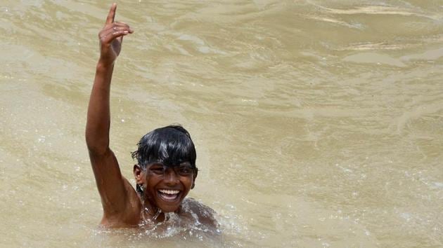 TAKE A DIP: A boy is all smiles as he bathes in the Sidhwan Canal in Ludhiana. (Gurminder Singh/HT )