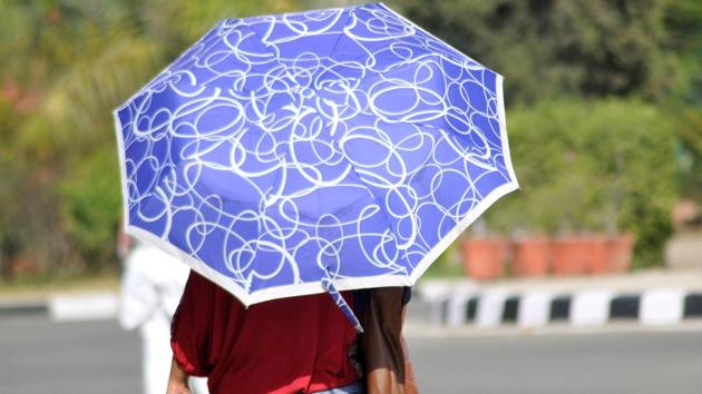 UNDER MY UMBRELLA: A Ludhiana girl uses the good, old umbrella to protect herself. (Gurminder Singh/HT )
