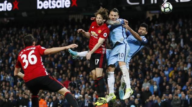 Manchester City F.C.'s Sergio Aguero (right) and Nicolas Otamendi attempt an header at goal with Manchester United F.C.'s Daley Blind trying to defend during their English Premier League match -- The Manchester Derby -- on Thursday. (Reuters) Manchester City F.C.'s Sergio Aguero (right) and Nicolas Otamendi attempt an header at goal with Manchester United F.C.'s Daley Blind trying to defend during their English Premier League match -- The Manchester Derby -- on Thursday. (Reuters)