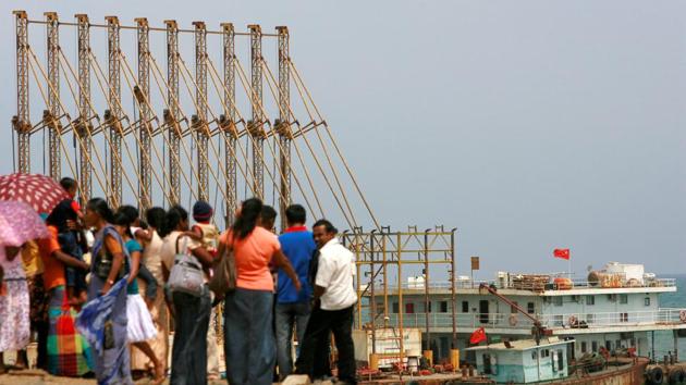 A group of Sri Lankan visitors at the new deep water shipping port watch Chinese dredging ships work in Hambantota, 240 km southeast of Colombo.(REUTERS)