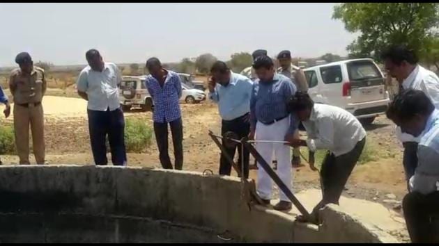 Officials stand around the well used by Dalits in Mana village in Agar Malwa district of Madhya Pradesh in which upper caste villagers allegedly poured kerosene.(HT PHOTO)