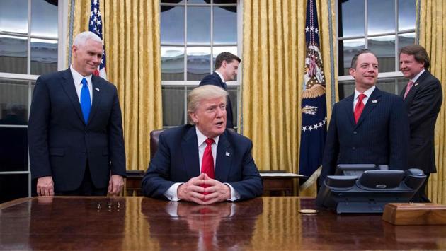 (FILES) US President Donald Trump (C) speaks to the press as he waits at his desk before signing conformations for General James Mattis as US Secretary of Defense and General John Kelly as US Secretary of Homeland Security, as Vice President Mike Pence (L) and White House Chief of Staff Reince Priebus (R) look on, in the Oval Office of the White House in Washington, DC, January 20, 2017. (JIM WATSON / AFP)