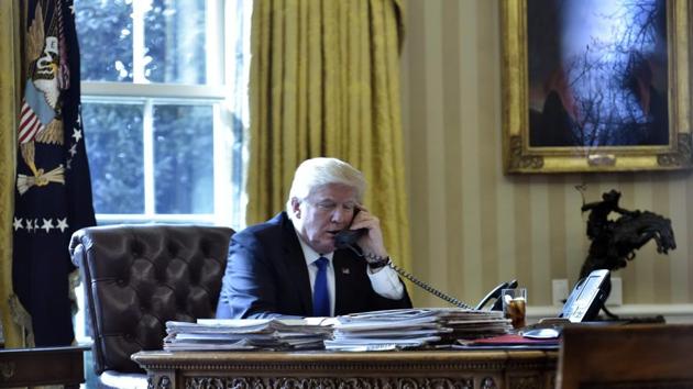 US President Donald Trump speaks on the phone with Russia's President Vladimir Putin from the Oval Office of the White House on January 28, 2017, in Washington, DC. (AFP)