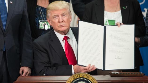 (FILES) US President Donald Trump signs an executive order to start the Mexico border wall project at the Department of Homeland Security facility in Washington, DC, on January 25, 2017. (AFP)