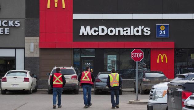 Construction workers enter a McDonald's. It brought to a standstill an oil rush that had started a decade earlier, when energy conglomerates including ExxonMobil, Shell, Statoil and Total bought up stakes while oil prices topped $100 a barrel. (Robyn Beck/AFP) Construction workers enter a McDonald's. It brought to a standstill an oil rush that had started a decade earlier, when energy conglomerates including ExxonMobil, Shell, Statoil and Total bought up stakes while oil prices topped $100 a barrel. (Robyn Beck/AFP)