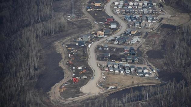 An aerial view of a residential neighbourhood in Fort McMurray, Canada, where some homes have been rebuilt but many have not, one year after the Fort McMurray fire. A few late-season snowflakes flutter over Fort McMurray, their whiteness contrasting against surrounding forests blackened one year ago by the most destructive wildfire in Canadian history. On May 1, 2016, a brushfire in the Canadian oil patch erupted into a huge blaze that over the following two months would engulf nearly 600,000 hectares of the boreal forest and force the evacuation of the entire city of 100,000 people. (Robyn Beck/AFP) An aerial view of a residential neighbourhood in Fort McMurray, Canada, where some homes have been rebuilt but many have not, one year after the Fort McMurray fire. A few late-season snowflakes flutter over Fort McMurray, their whiteness contrasting against surrounding forests blackened one year ago by the most destructive wildfire in Canadian history. On May 1, 2016, a brushfire in the Canadian oil patch erupted into a huge blaze that over the following two months would engulf nearly 600,000 hectares of the boreal forest and force the evacuation of the entire city of 100,000 people. (Robyn Beck/AFP)